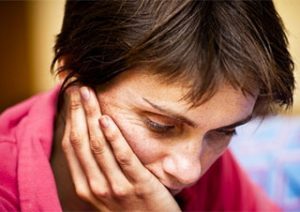 woman holding her face