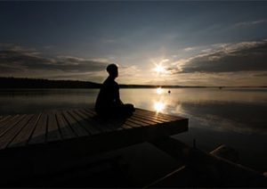 person medidating on a pier